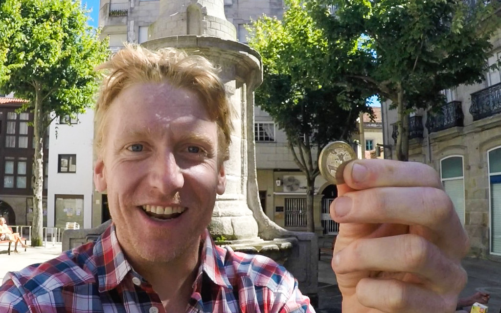 Alastair Humphreys holding a Euro coin he earned playing the violin