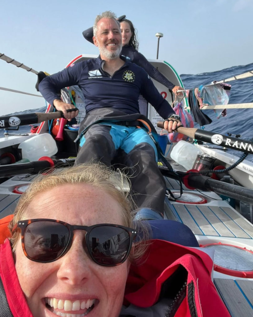 Rowers from Atlantic Fusion take a break on board, sat with rows on their boat out at sea